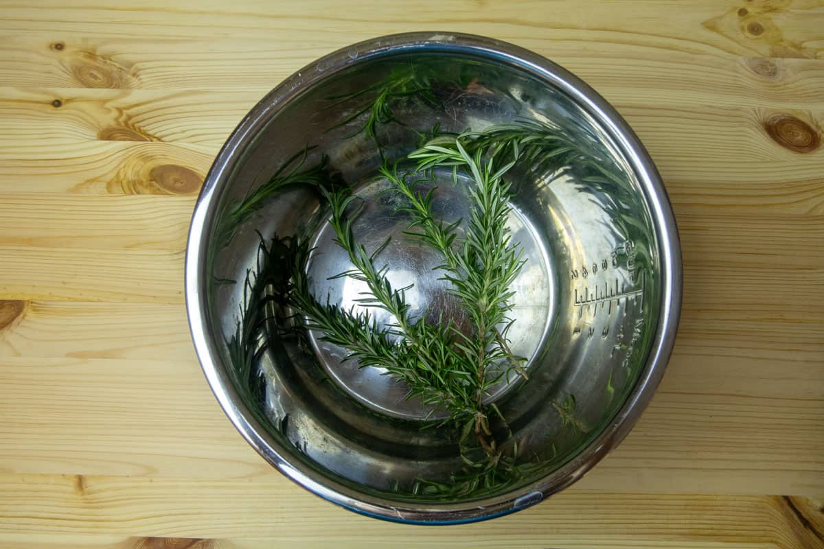 Inner pot of Instant Pot with rosemary sprigs