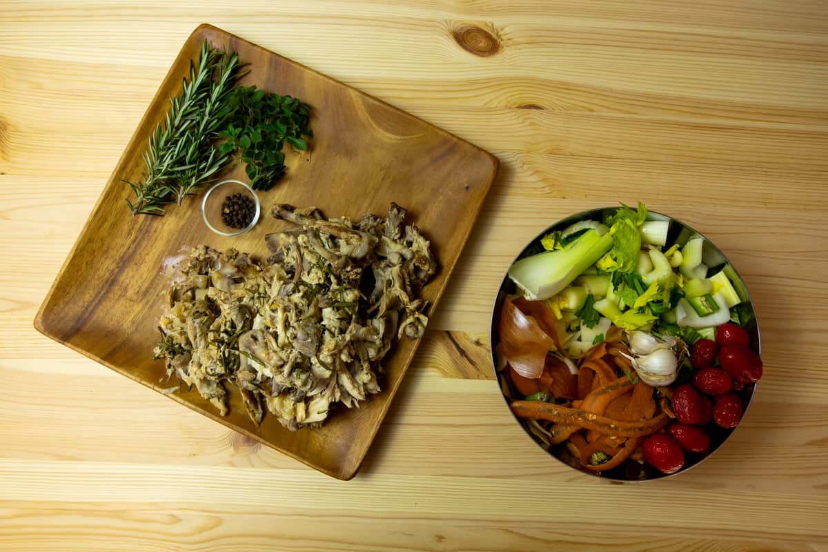 Plate with chicken bones and bowls with vegetable scraps