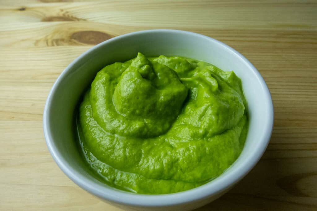 A bowl filled with creamy  tomatillo avocado salsa.