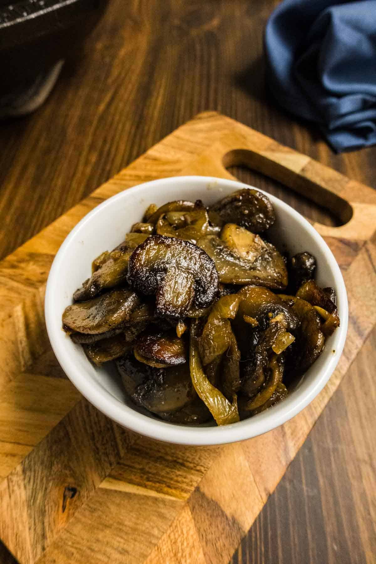 Mushrooms and onions in a bowl looking delicious.