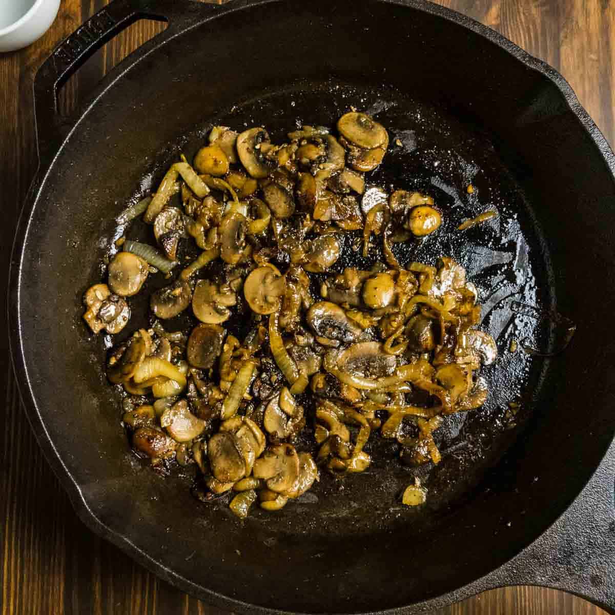 Finished caramelized onions and mushrooms in a cast iron pan.