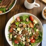 Arugula and Spinach salad with steak with dressing.