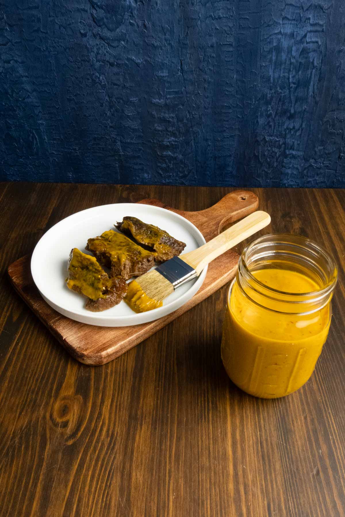 Carolina mustard BBQ sauce with boneless beef short ribs and a pastry brush.