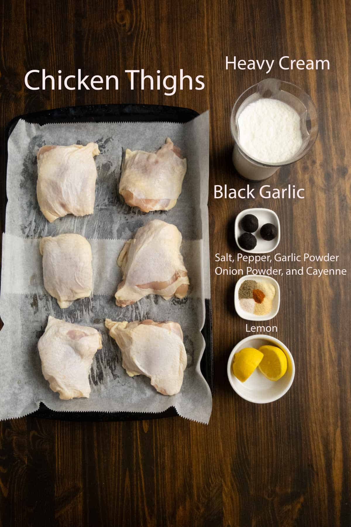 Ingredient sot of chicken thighs, cream, black garlic, and lemon.