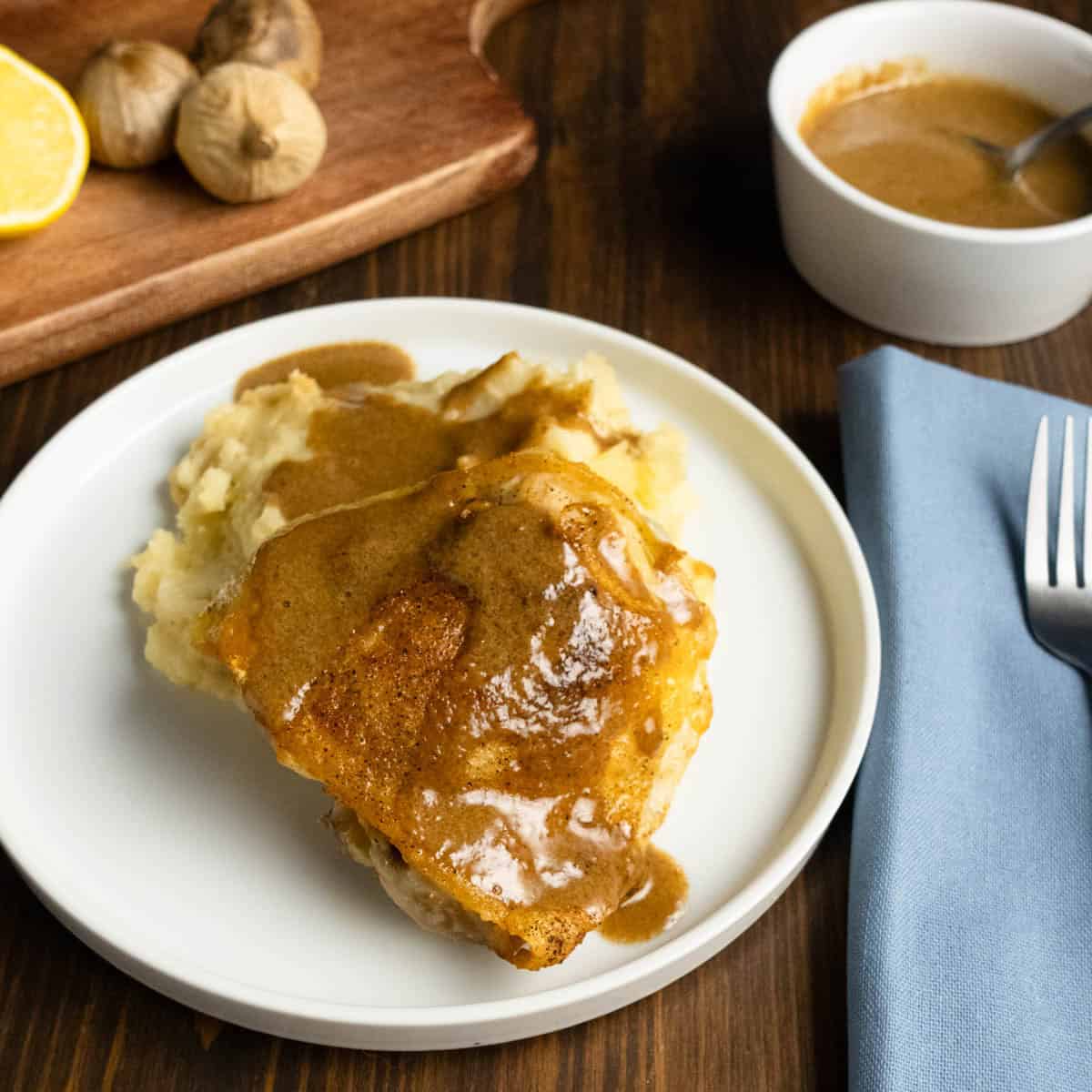 Crispy chicken thigh with back garlic sauce on top and rosemary mashed potatoes.