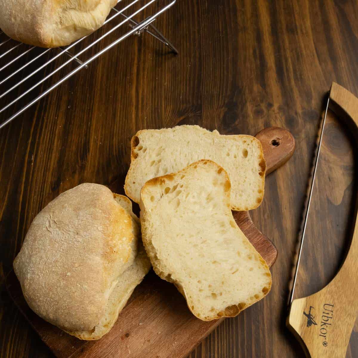 Ciabatta bread rolls cut open on a cutting board.