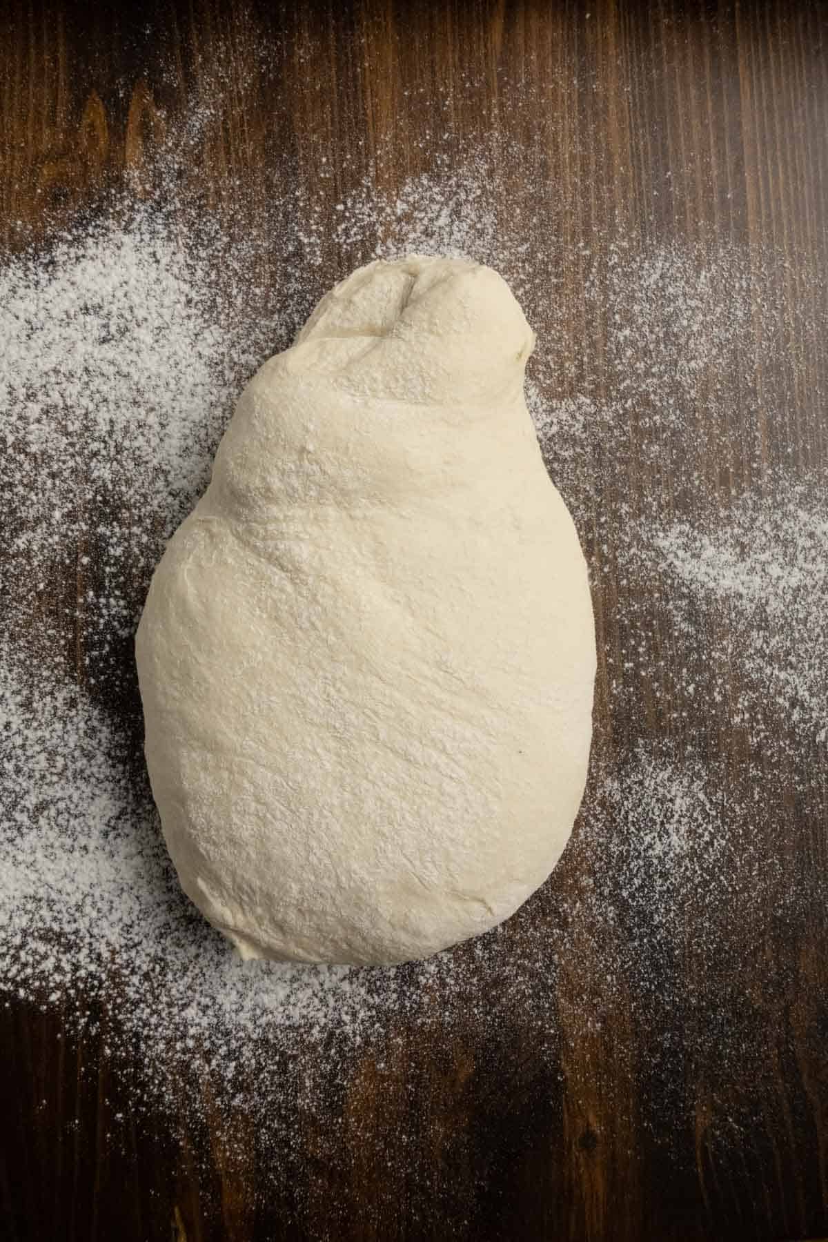 Unshaped ciabatta dough on the floured work surface.