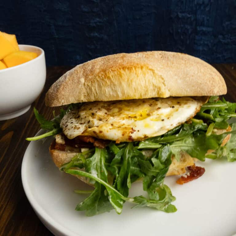 Close up of a runny yolk egg sandwich on ciabatta.