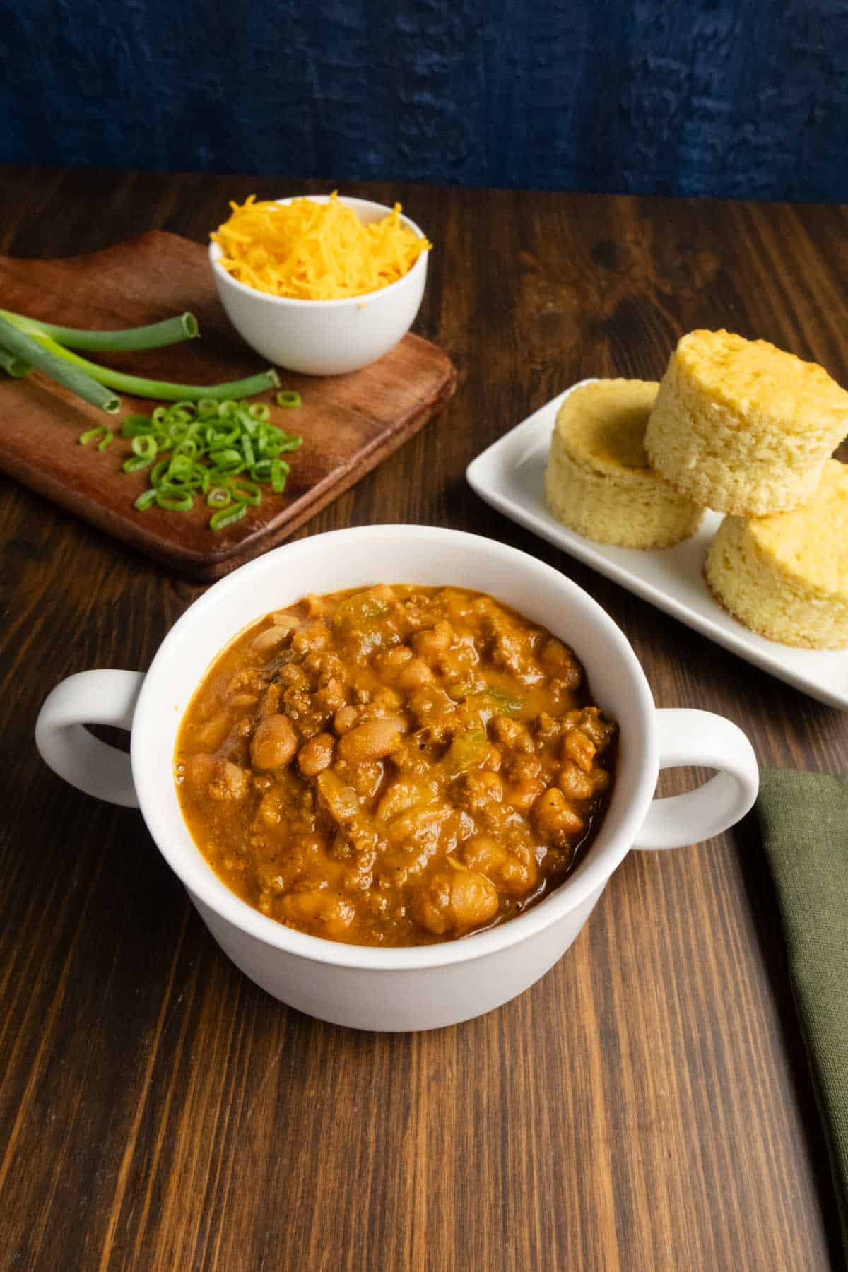 Chili with dried beans and cornbread in the background.
