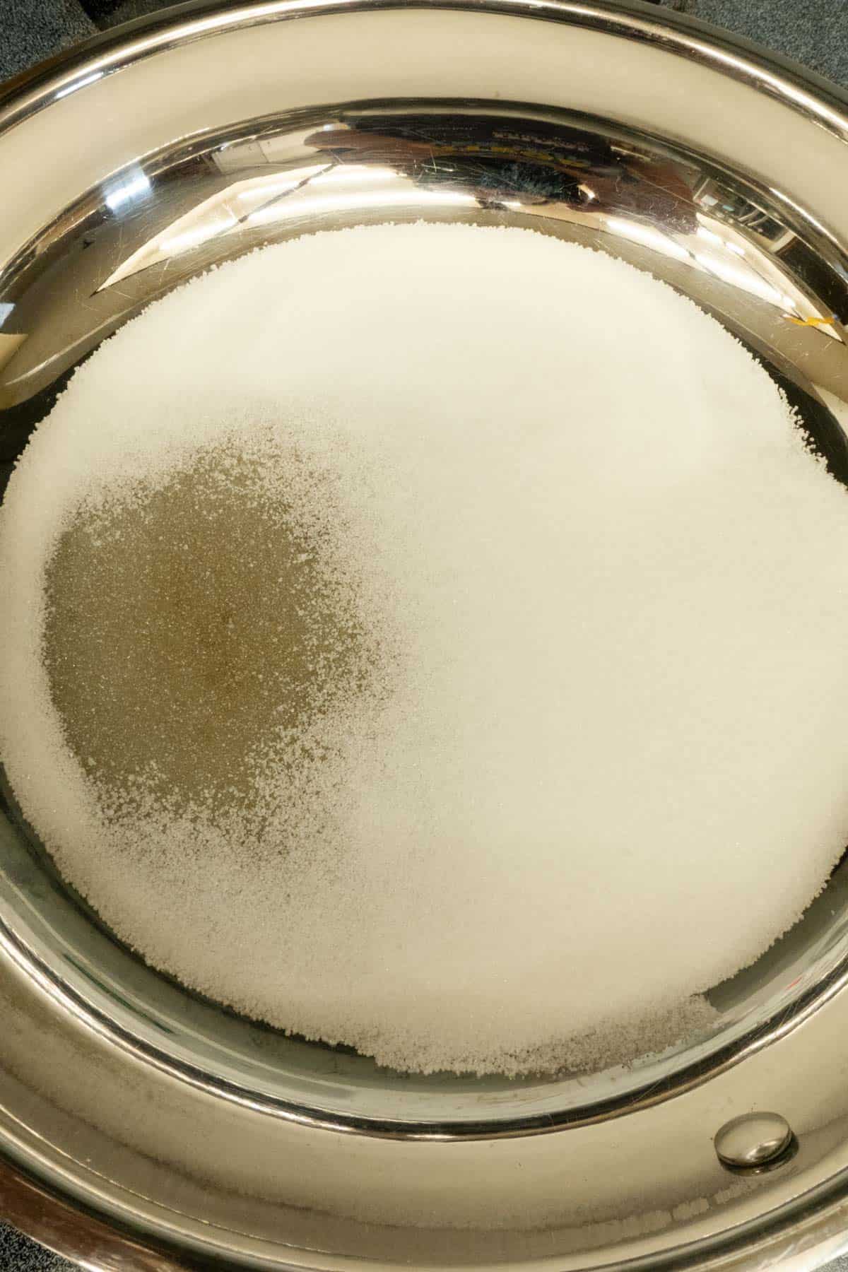 Sugar in a skillet beginning to melt.