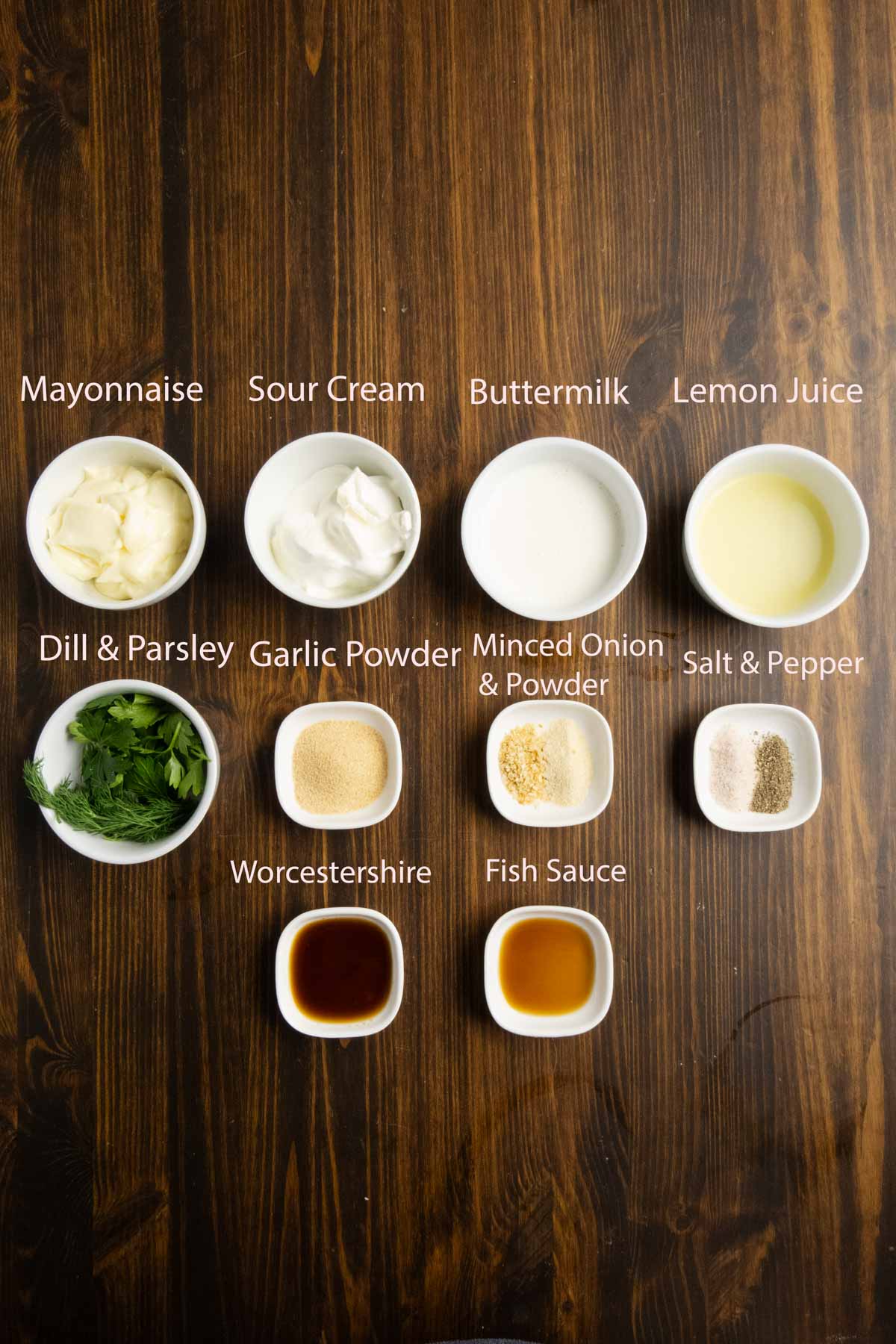 Ingredient shot of mayo, sour cream, buttermilk, lemon, dill, parsley, garlic and onion powder, fish sauce, and worcestershire sauce.