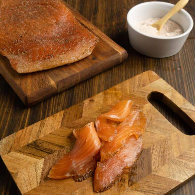 Hunk of salmon with salmon ribbons and salt in the background.