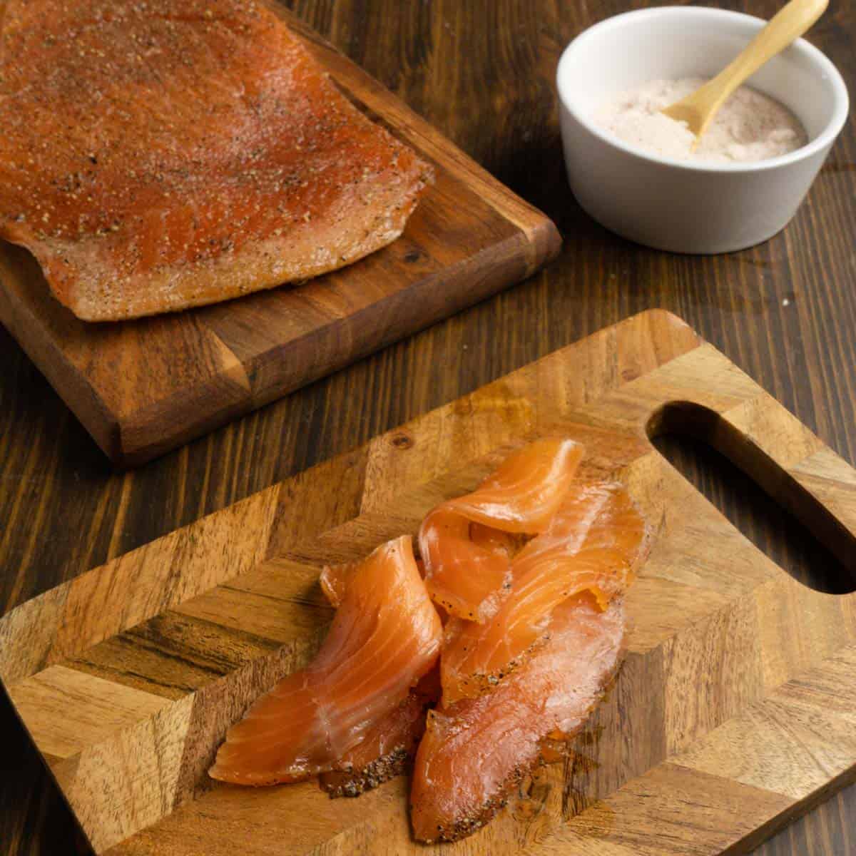 Hunk of salmon with salmon ribbons and salt in the background.