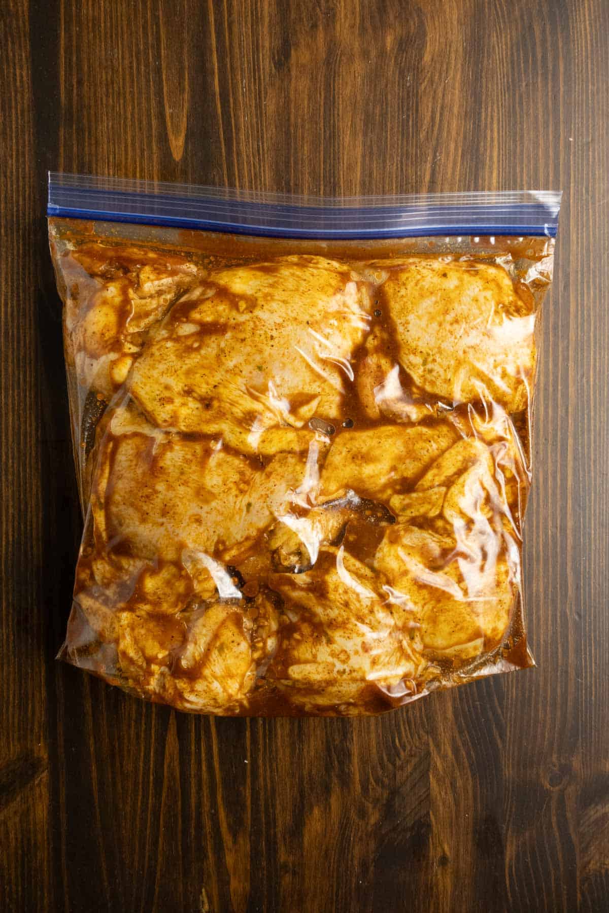 Bag of sealed chicken coated in a marinade.