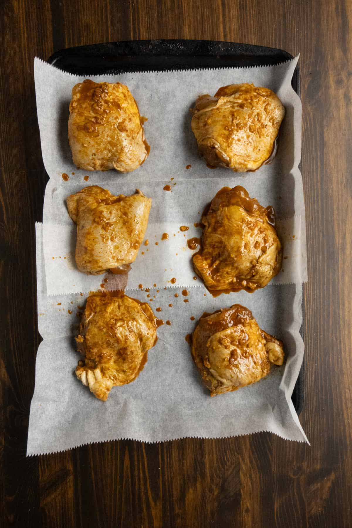 Chicken thighs on a baking sheet before cooking.