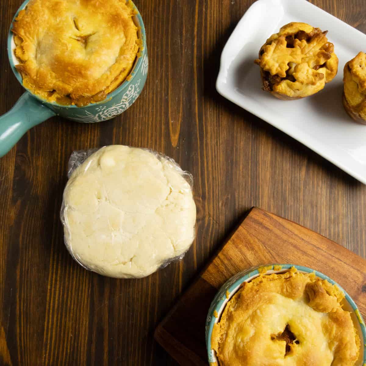 All butter pie dough wrapped in plastic wrap with chicken pot pie around it.