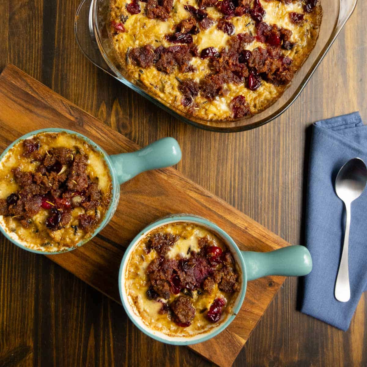 Two bowls filled with chicken and wild rice casserole with a pan of casserole in the back.