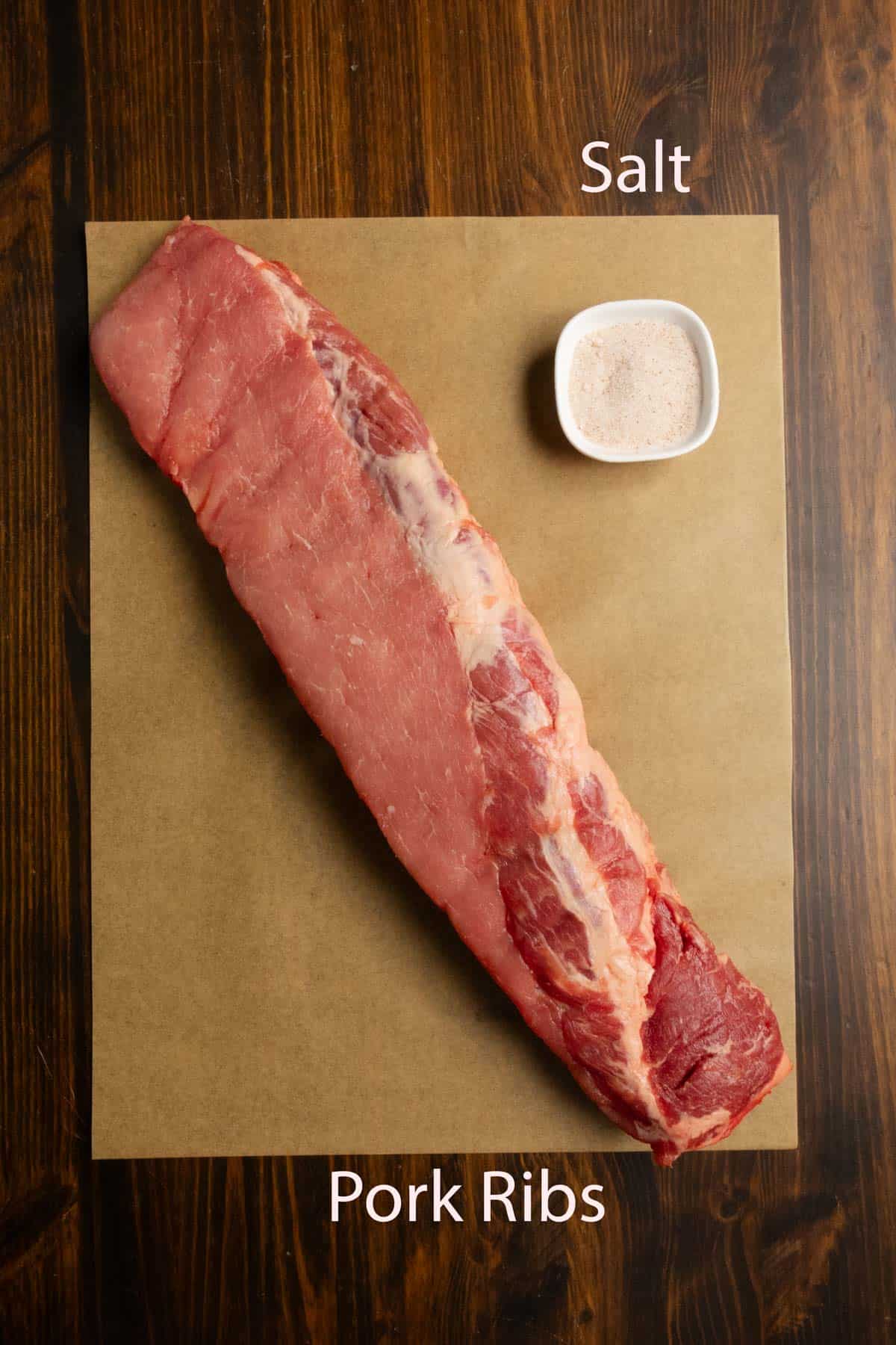 Ingredient shot of a rack of pork ribs and salt.