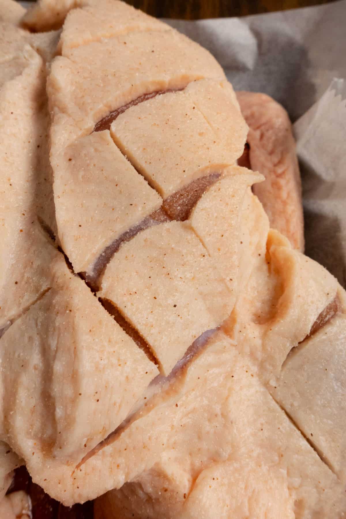 Close up on the duck after it's been cut in the fat with the salt on it.