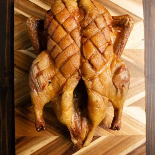 Dry brined roasted whole duck on a cutting board.