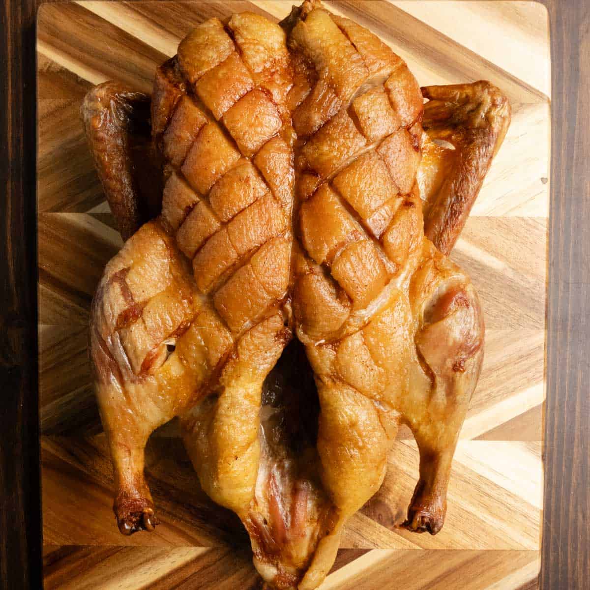 Dry brined roasted whole duck on a cutting board.