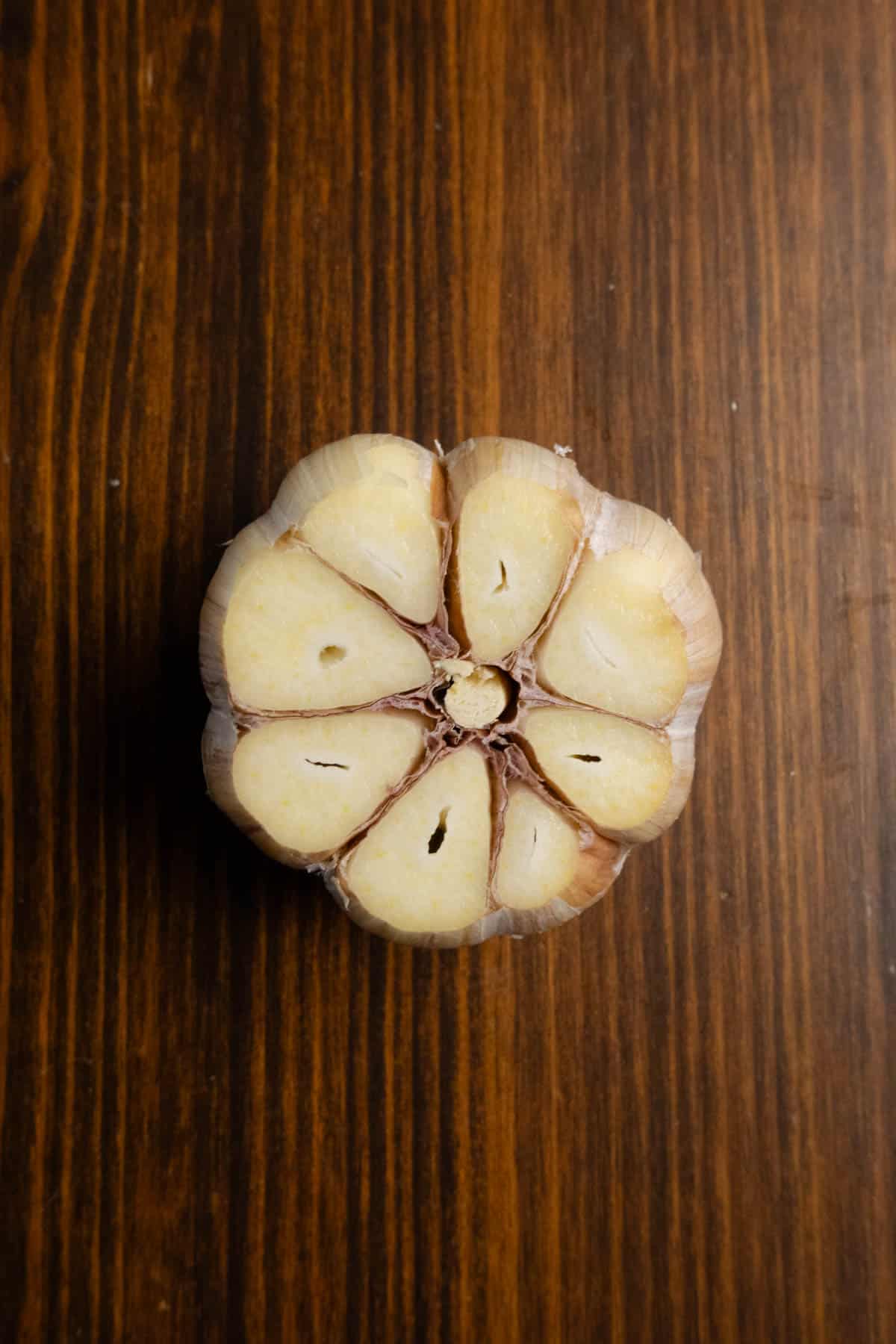 A cut garlic bulb showing the exposed cloves ready for oil and salt.