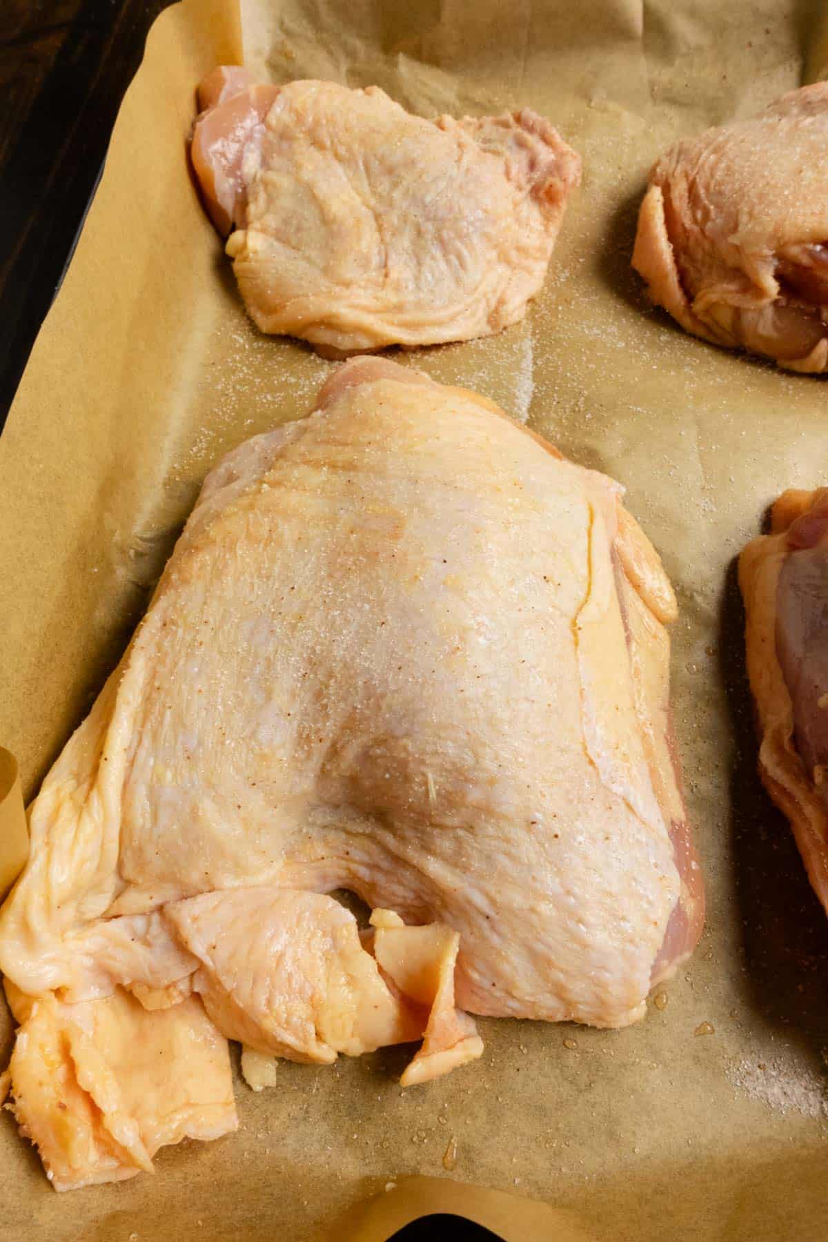 Close up on the chicken thighs to show the density of salt on the skin.