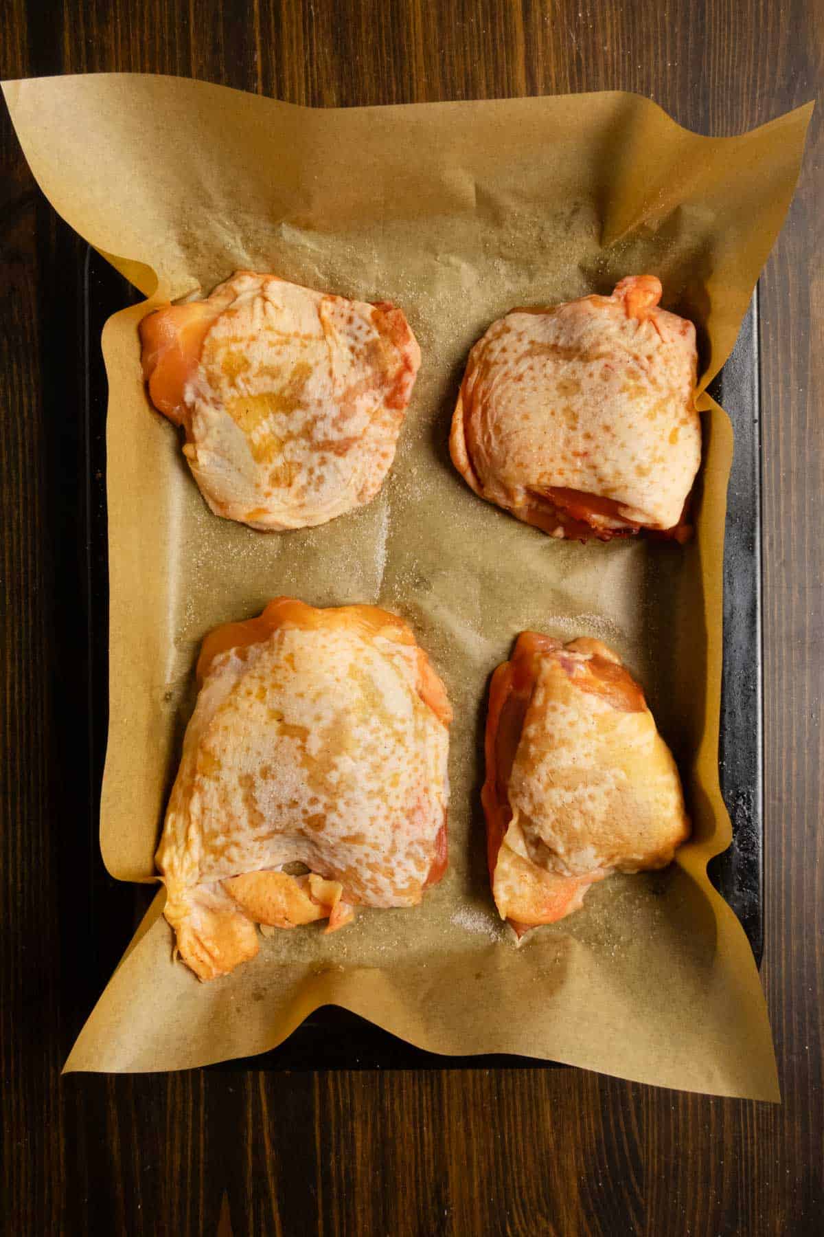 Chicken thighs after they've been dry brined to show how they look so you're not worried to cook them.